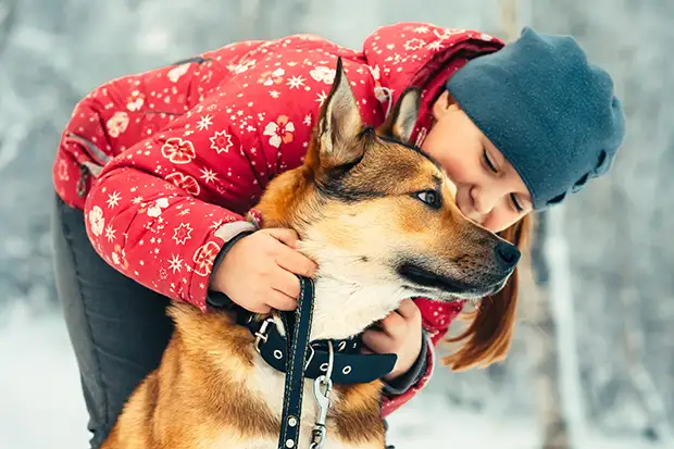 Mädchen mit Hund im Schnee
